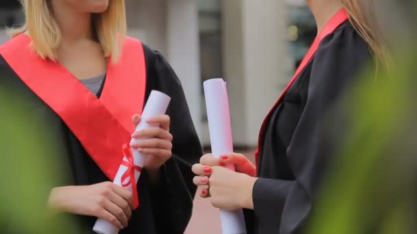 Dois estudantes bonitos conversando no parque após a cerimônia de formatura, futuro feliz — Vídeo de Stock