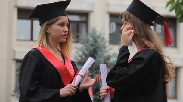 Mulheres diplomadas atraentes que possuem diplomas e falam sobre carreira futura — Vídeo de Stock