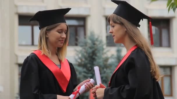 Estudiantes hablando de futuro después de la ceremonia de graduación en el parque, educación — Vídeo de stock