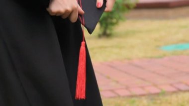 Mezuniyet kapağı kırmızı Püskül, töreni ile tutarak akademik elbiseli kadın