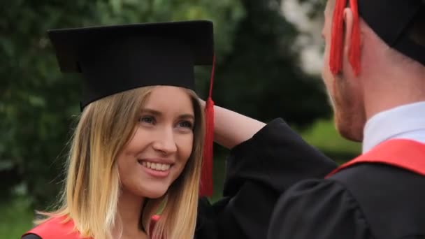 Heureux couple d'étudiants embrassant et se retournant, cérémonie de remise des diplômes — Video