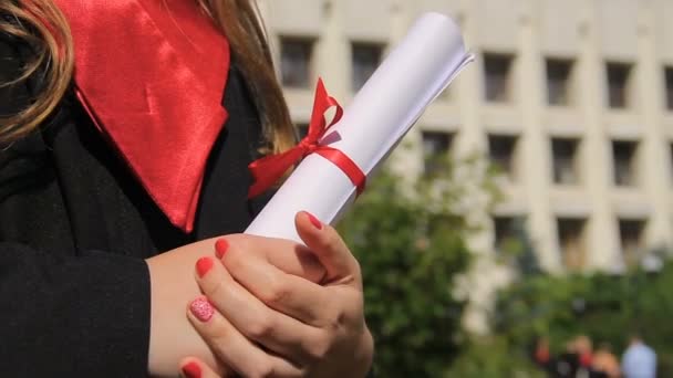 Žena oblečená v promoce talár držení diplomu, při pohledu do šťastné budoucnosti — Stock video
