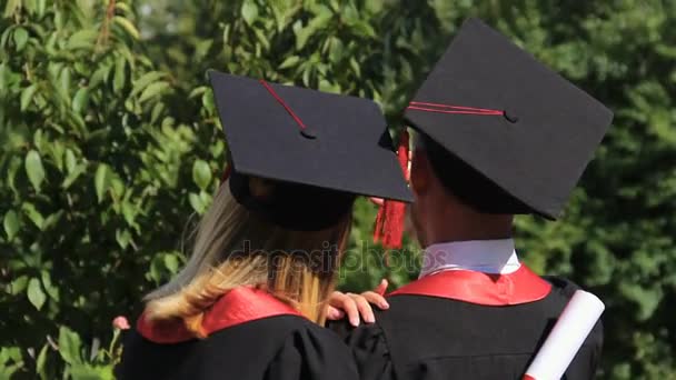 Lyckliga par utexaminerade tar selfie på smartphone i parken nära academy — Stockvideo