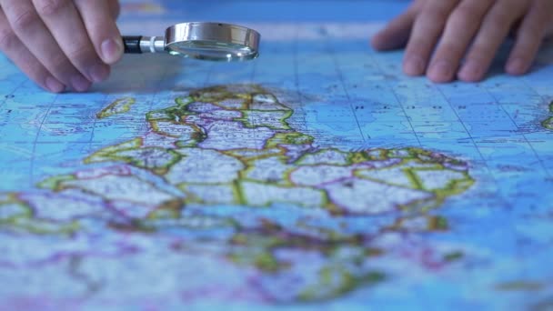 Persoon kijken naar Afrika op kaart via Vergrootglas, reis bestemming — Stockvideo