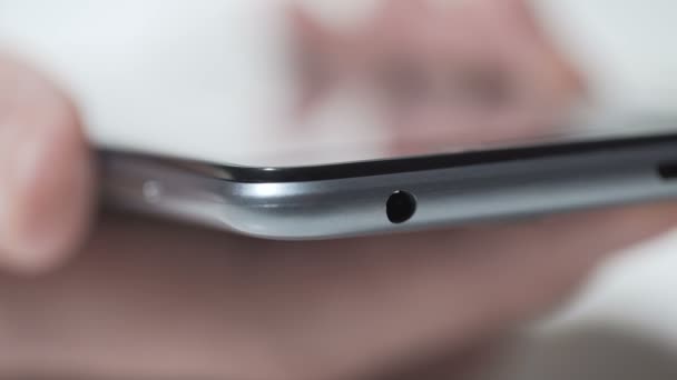 Close-up de pessoa conectando fones de ouvido para smartphone moderno, centro de serviços — Vídeo de Stock
