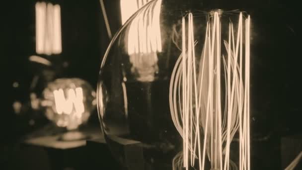 Incandescent tungsten filament trembling in light bulb, creative interior design — Stock Video