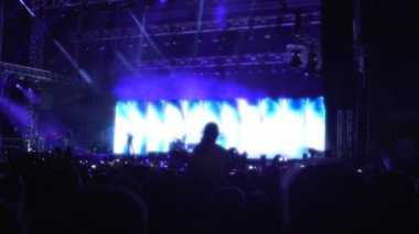 Birçok insan siluetleri seyirci izlerken gösterinin konserinde müzik keyfi
