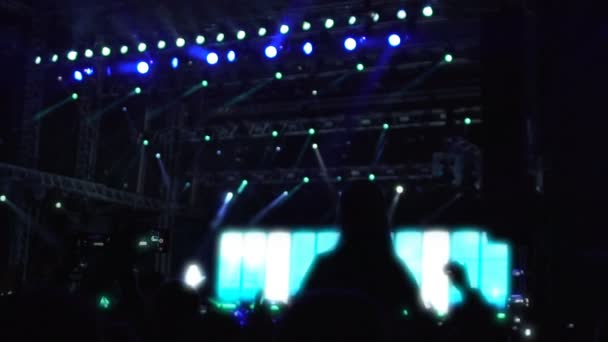 Силуэты взволнованной публики, наслаждающейся рок-концертом, машущими руками и танцующими — стоковое видео