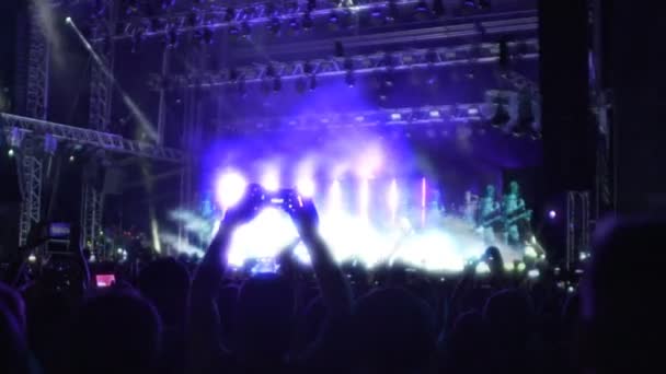 Fantástico espectáculo de música en el escenario iluminado, siluetas del público viendo espectáculo — Vídeos de Stock