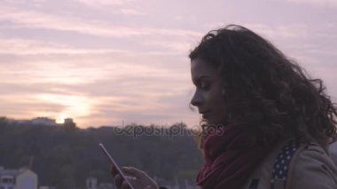 Genç Bayan sosyal ağlar yüzünde gülümseme ile smartphone cep telefonu ile mesaj okuma