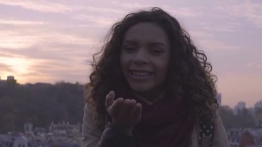 Yüzünde gülümseme ile kamera için poz hava öpücük, yapma güzel karışık ırk kadın