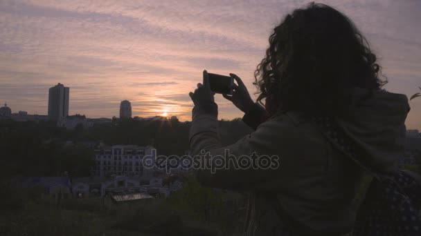 Glad kvinnlig student Filmning av vacker solnedgång i storstad på gadget — Stockvideo