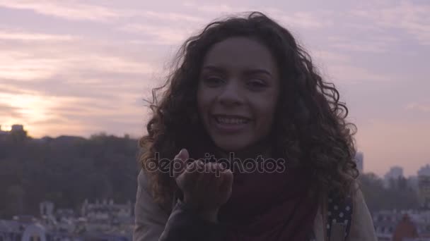 Hermosa mujer de raza mixta haciendo beso de aire, posando para la cámara con sonrisa en la cara — Vídeos de Stock