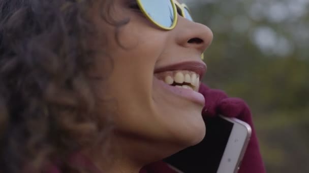 Şık genç kadın telefonla konuşuyor, gülüyor ve gülümseyen güneş gözlüğü — Stok video