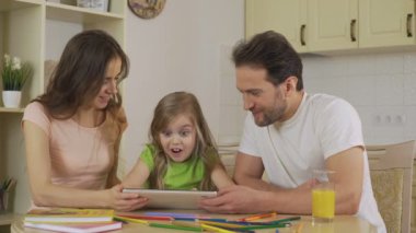 Anne, kızı uygulamasını tablet üzerinde gösteren heyecanlı kız gösterilen başparmak-up