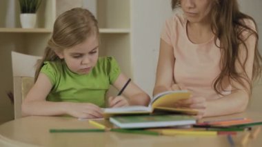 Üzgün küçük kız ile sıkılmış ya da ödev yorgun anne, okul görevleri yapmak