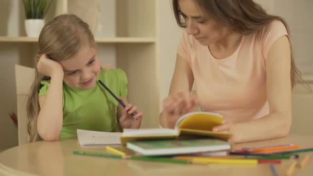 Мати дочка допомоги з домашнє завдання, щасливі розумна дівчинка насолоджуючись домашню освіту — стокове відео