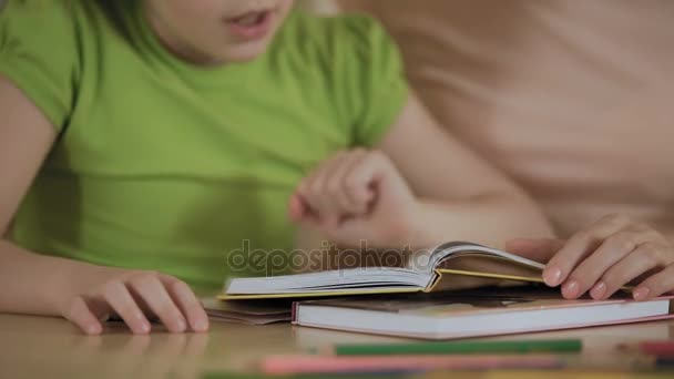 Irriterad liten flicka lära sig läsa bok med mor, uttråkad med Hemundervisning — Stockvideo
