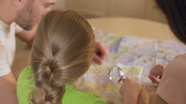 Γονείς και κόρη κοιτάζοντας χάρτη, σχεδιασμός προορισμός για τις καλοκαιρινές διακοπές — Αρχείο Βίντεο