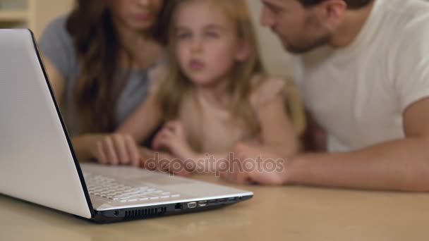 Familia que usa el portátil para ir de compras, reservar entradas en línea o ver fotos — Vídeos de Stock