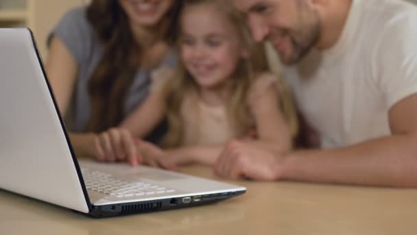 Pais felizes e filha olhando para laptop, menina desfrutando de educação à distância — Vídeo de Stock