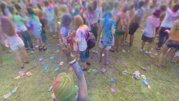 Πολλοί χαρούμενοι άνθρωποι που καλύπτονται από πολύχρωμα χρώματα απολαμβάνοντας Φεστιβάλ, χορεύοντας στη μουσική — Αρχείο Βίντεο