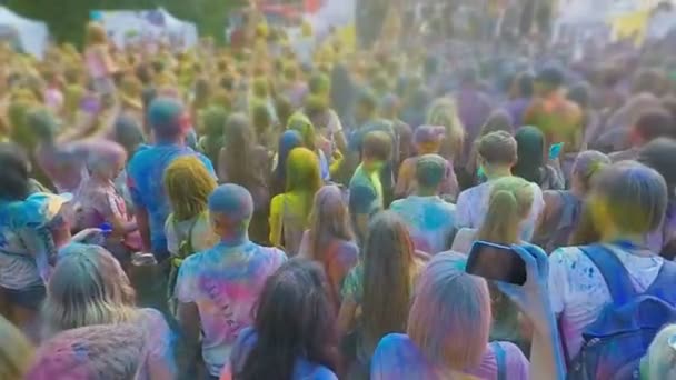 Tłum podekscytowany młodych ludzi skoki i rozpylanie barwnika w proszku festiwalu Holi — Wideo stockowe