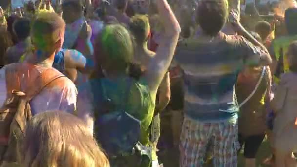 Outdoor music festival audience covered in colorful paint jumping at concert — Stock Video