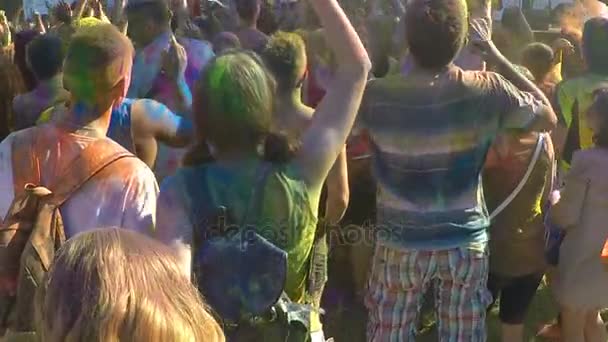 Активные юноши и девушки в цветовой гамме прыгают под музыку на фестивале — стоковое видео