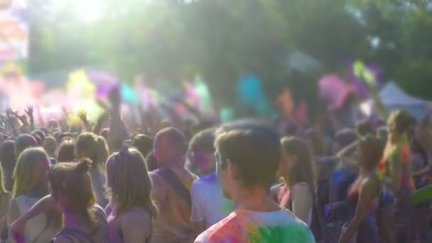 Atmosfera al festival del colore all'aperto, molte persone che lanciano coloranti in polvere nell'aria — Video Stock