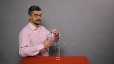 Erkek dökme maden suyu tatma ve başparmak yukarıya, kaliteli gösterilen cam,