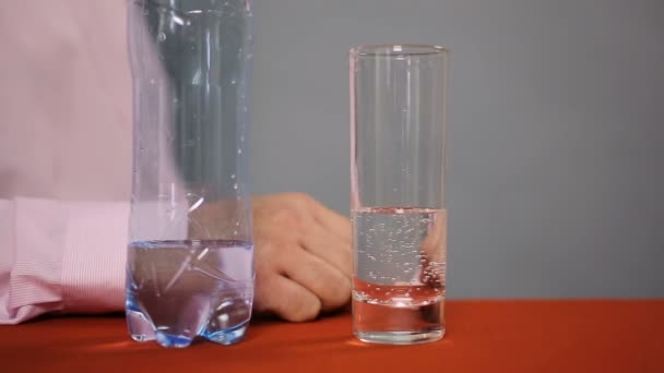 Bottle of mineral sparkling water and glass with beverage standing on the table — Stock Video