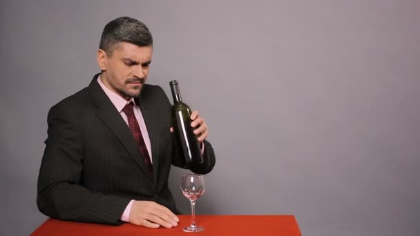 Enttäuschter Mann im schwarzen Anzug, der billigen Rotwein probiert, unzufriedener Winzer — Stockvideo