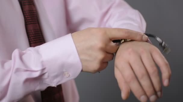 Persona de negocios poniéndose el reloj de pulsera y la hora de chequeo, tiro de cerca — Vídeos de Stock