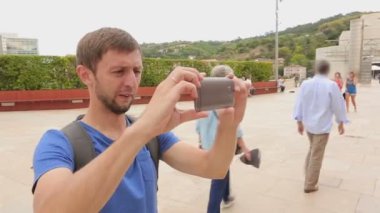 Fotoğrafların görüntülenmesi erkek turistik gezi sırasında cep telefonu kamera aldı