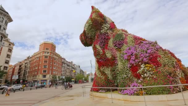 Cãozinho de flor gigante em pé em frente ao museu Guggenheim em Bilbao, Espanha — Vídeo de Stock
