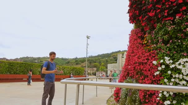 Мужской турист любовался красотой флористического дизайна цветочной скульптуры в городе — стоковое видео