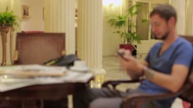 Otel lobisinde, posta kontrol adam sabah kahve içme genç sakallı