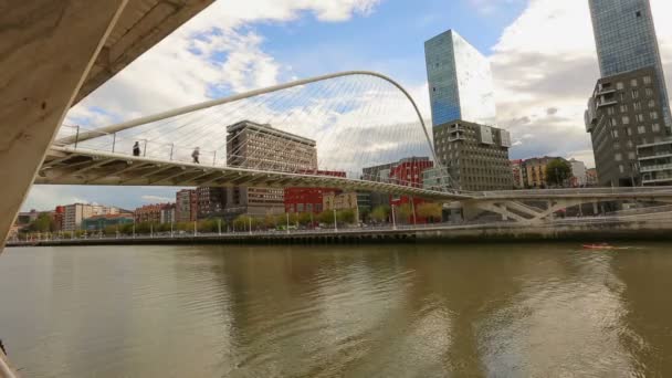 People walking across contemporary Zubizuri glass bridge in Bilbao, Spain — Stock Video