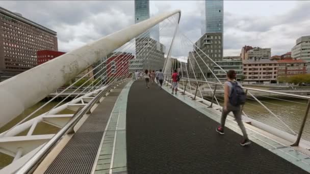 ビルバオ、スペインのネルビオン川に架かるズビズリ橋を渡って散歩歩行者 — ストック動画