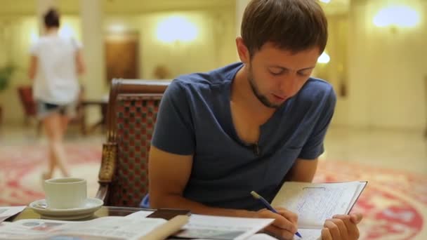 Joven periodista tomando notas, preparándose para la conferencia de prensa en el vestíbulo del hotel — Vídeo de stock