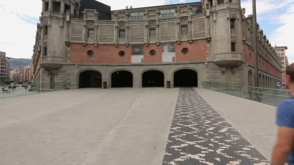 Man walking toward main facade of Azkuna Zentroa culture center in Bilbao, Spain — Stock Video