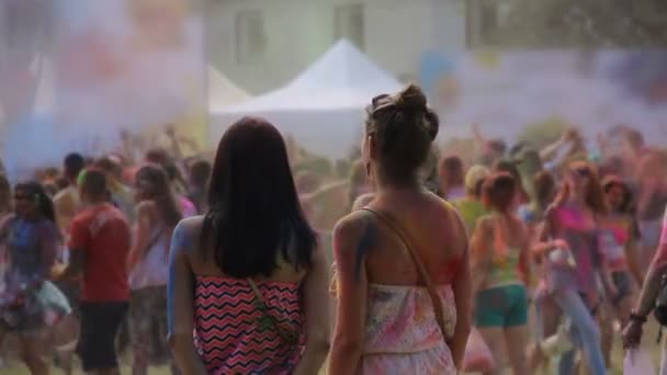 Amigos femeninos cubiertos de polvo colorido disfrutando del fresco festival Holi en el parque — Vídeos de Stock