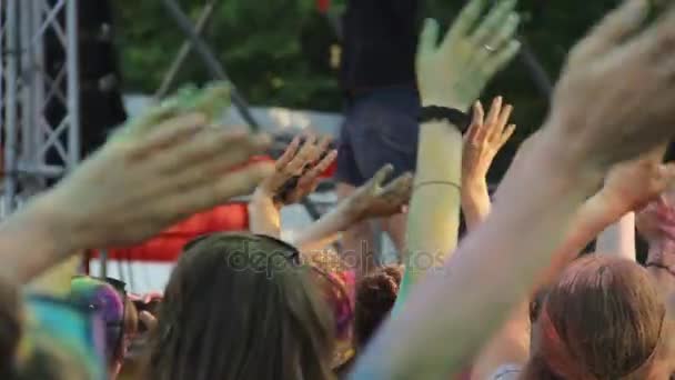Holi fest, vrolijke vrouwen en mannen zwaaien handen voor podium, open lucht partij — Stockvideo