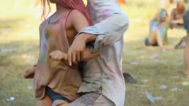 Happy man dancing with female friend at Holi festival, open-air party, relax — Stock Video