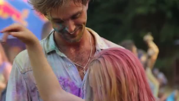 Bela mulher beijando namorado na festa Holi, casal dançando na festa legal — Vídeo de Stock