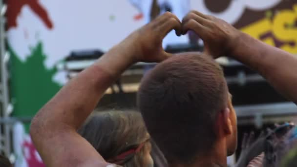 Атлетик показывает знак любви руками и танцует на музыкальном концерте — стоковое видео