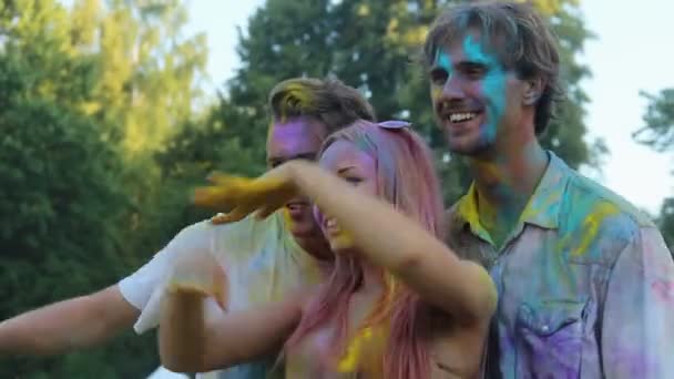 Smiling friends colored with powder paint having fun and posing for camera — Stock Video