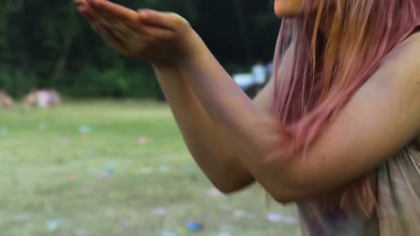 Hezká žena vyfukování barevné malby od palmy a pózuje pro kameru, Holi Festival — Stock video