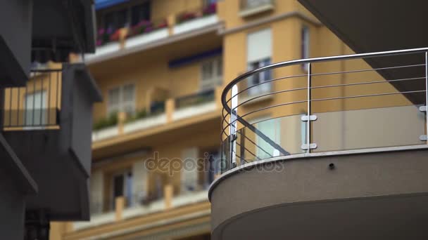 Janelas de bloco de vários andares de apartamentos na cidade europeia, varandas com flores — Vídeo de Stock